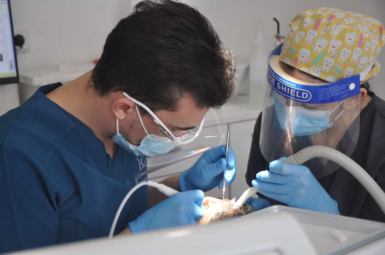 Un dentiste pratique une opération à une patiente